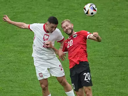 Polens Bartosz Slisz (l) im Kopfballduell mit dem Österreicher Konrad Laimer. - Foto: Michael Kappeler/dpa