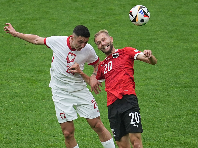 Polens Bartosz Slisz (l) im Kopfballduell mit dem Österreicher Konrad Laimer. - Foto: Michael Kappeler/dpa