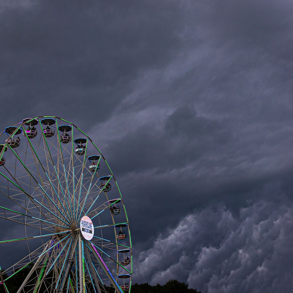 Dunkle Regenwolken ziehen über ein Riesenrad auf dem Gelände des Hurricane-Festivals in Scheeßel hinweg. - Foto: Moritz Frankenberg/dpa