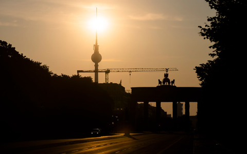 Das Brandenburger Tor und der Fernsehturm sind im Gegenlicht der aufgehenden Sonne zu sehen. Am Montag zeigt sich laut Vorhersage meist die Sonne, höchstens wird es locker bewölkt. - Foto: Christoph Soeder/dpa