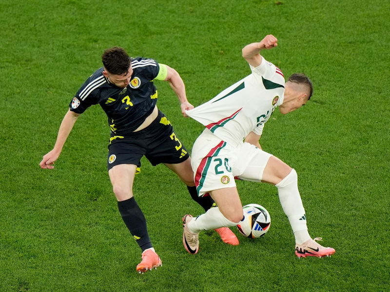 Die Ungarn um Roland Sallai (r) holten gegen Andrew Robertson und Schottland einen späten Sieg. - Foto: Bradley Collyer/PA Wire/dpa