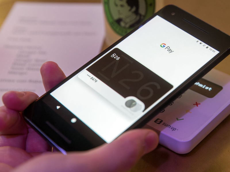 Ein Gast demonstriert mit einem Smartphone und der App in einem Cafe das Bezahlen mit dem Handy. - Foto: Jens Büttner/dpa-Zentralbild/dpa