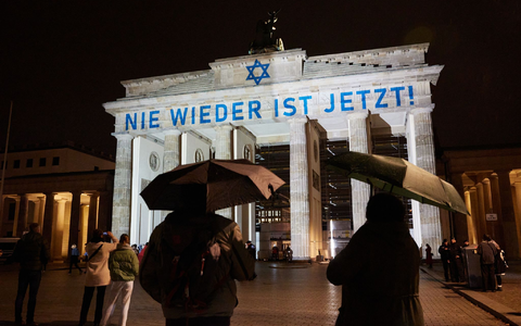 Der Schriftzug «Nie wieder ist jetzt» wird zum 85. Jahrestag der Pogromnacht an das Brandenburger Tor projiziert (Archivbild). - Foto: Jörg Carstensen/dpa