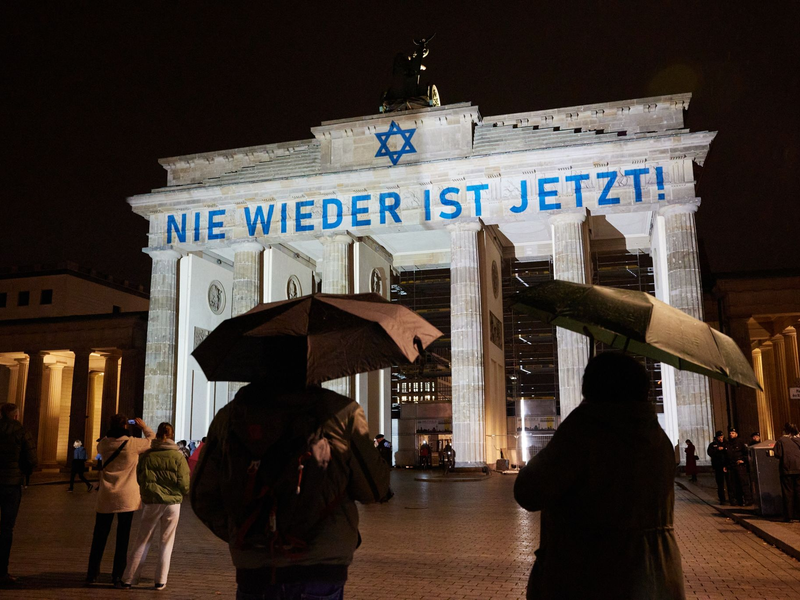 Der Schriftzug «Nie wieder ist jetzt» wird zum 85. Jahrestag der Pogromnacht an das Brandenburger Tor projiziert (Archivbild). - Foto: Jörg Carstensen/dpa