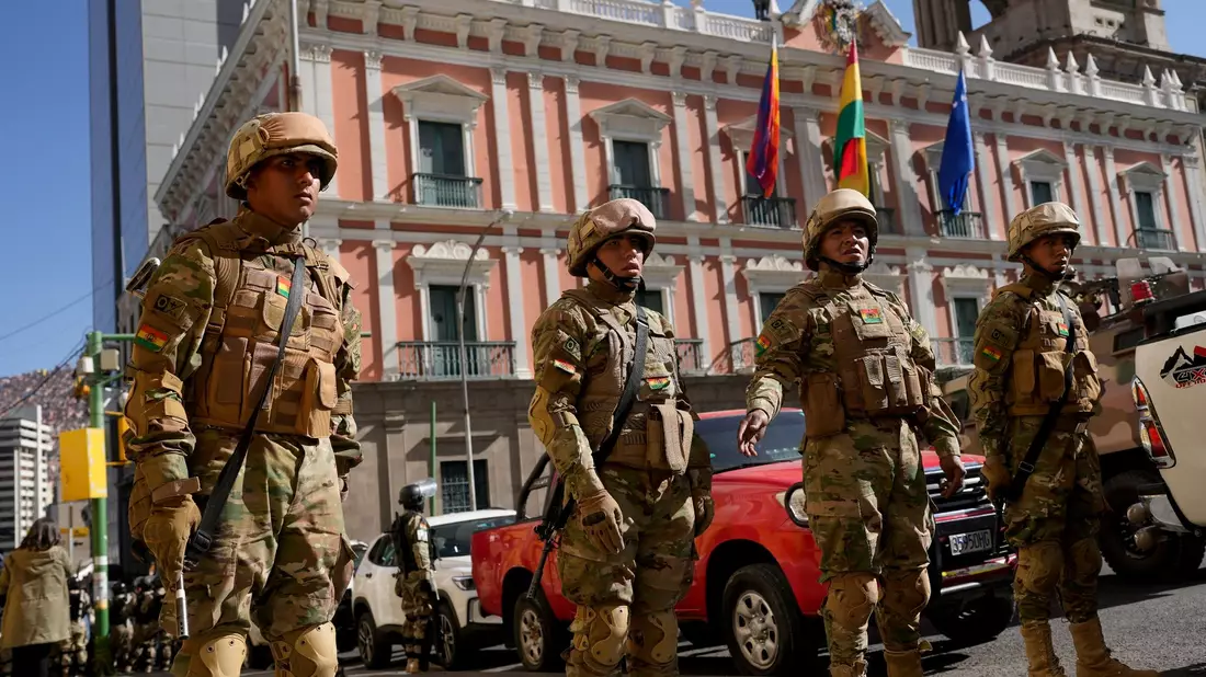 Soldaten ziehen sich zum Regierungspalast zurück, nachdem sie die bolivianische Nationalflagge auf dem Murillo-Platz in La Paz eingeholt haben. - Bild: Juan Karita/AP