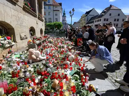 Menschen gedenken in Döbeln der getöteten Valeriia. - Foto: Robert Michael/dpa