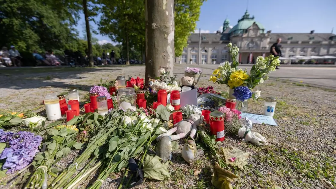 Blumen, Kerzen und handgeschriebene Trauerbekundungen an einem Baum im Kurpark Bad Oeynhausen. - Bild: Str/dpa
