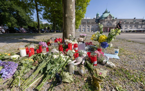 Blumen, Kerzen und handgeschriebene Trauerbekundungen stehen an einem Baum im Kurpark Bad Oeynhausen. - Foto: Str/dpa