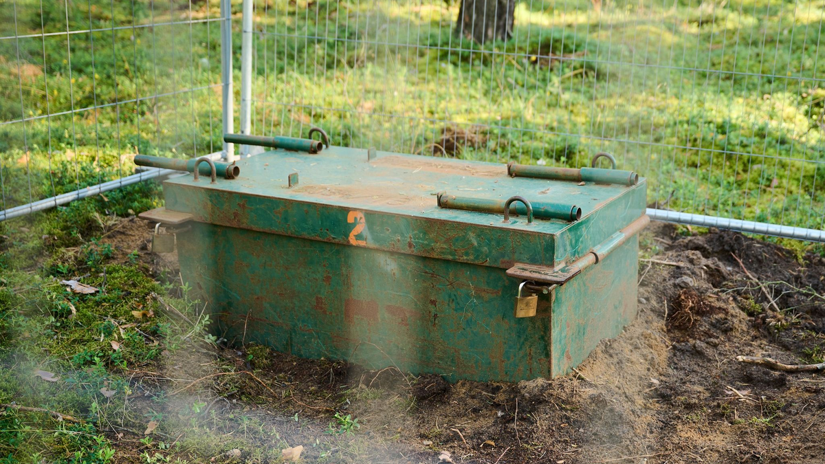 Eine Kampfmittelaufbewahrungskiste in einem abgesperrten Bereich des Waldes. - Foto: Annette Riedl/dpa