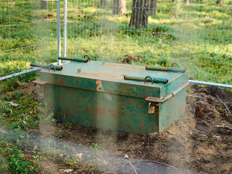Eine Kampfmittelaufbewahrungskiste in einem abgesperrten Bereich des Waldes. - Foto: Annette Riedl/dpa