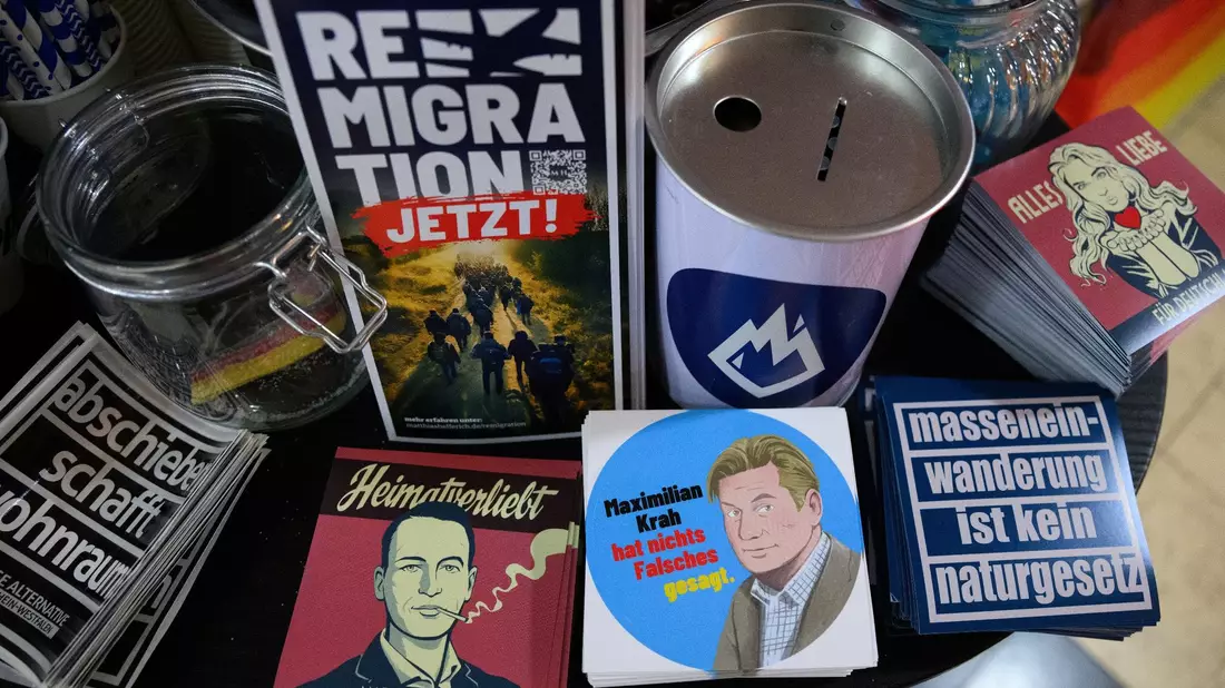Flyer und Aufkleber mit Slogans wie «Abschieben schafft Wohnraum» und «Remigration jetzt!» liegen am Stand der AfD-Jugendorganisation Junge Alternative beim Afd-Bundesparteitag. - Bild: Bernd von Jutrczenka/dpa