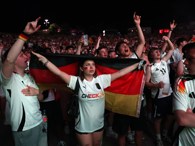 Zuschauer jubeln beim Spiel. - Foto: Karl-Josef Hildenbrand/dpa