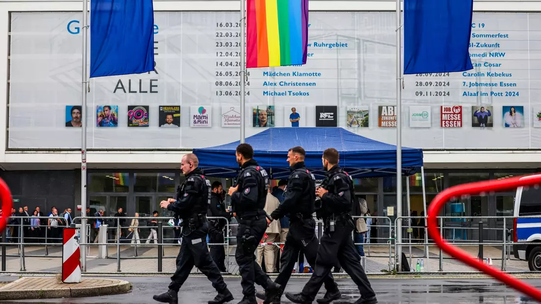 Polizeibeamte laufen im Regen an der Essener Grugahalle vorbei, wo der AfD-Parteitag stattfindet. - Bild: --/dpa