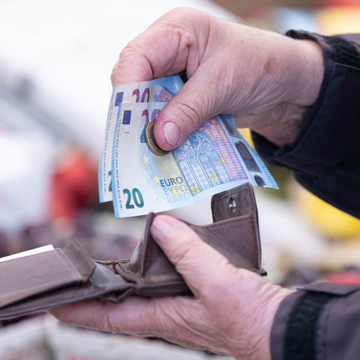 Eine Frau sortiert auf einem Wochenmarkt das Wechselgeld für ihre Einkäufe in ein Portemonnaie. - Foto: Sebastian Kahnert/dpa