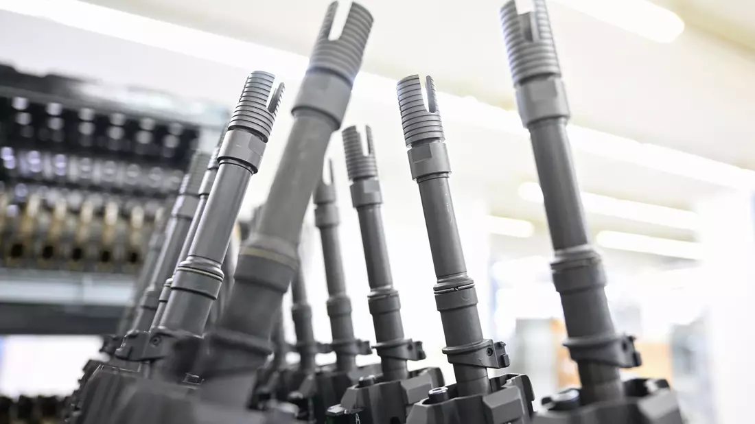 In einer Produktionshalle des Waffenherstellers Heckler & Koch in Oberndorf stehen fertige Sturmgewehre vom Typ HK416 aufgereiht. - Bild: Bernd Weißbrod/dpa
