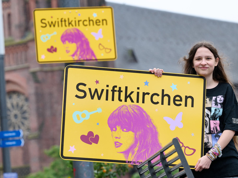 Die Stadt Gelsenkirchen wird im Juli Schauplatz für die «Eras Tour» von Superstar Taylor Swift - und gibt zu Ehren der Musikerin einen neuen Namen. Enthüllt wurde das «Swiftkirchen» von Swift-Fan Aleshanee Westhoff. - Foto: Bernd Thissen/dpa