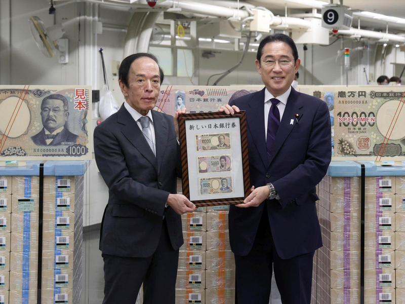 Japans Premierminister Fumio Kishida (r) und der Gouverneur der Bank of Japan, Kazuo Ueda, präsentieren die neuen Banknoten in Tokio. - Foto: Uncredited/Japan Pool via Kyodo News/dpa
