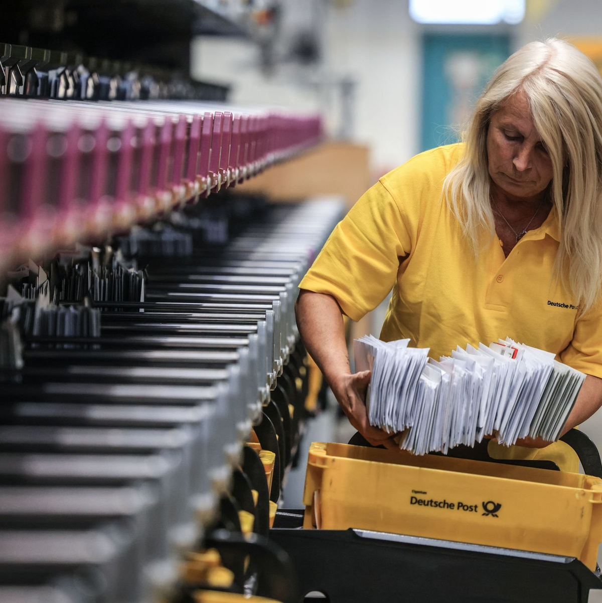 Eine Mitarbeiterin der Deutschen Post sortiert Briefe in einem Briefverteilzentrum. - Foto: Oliver Berg/dpa