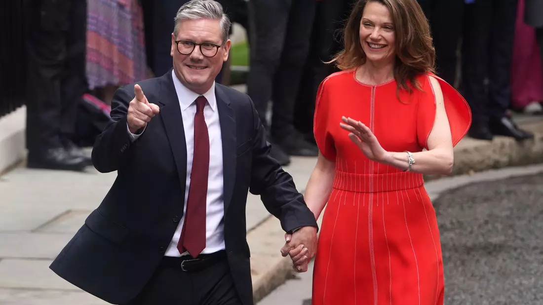 Starmer und Ehefrau Victoria winken ihren begeisterten Anhängern zu. - Bild: Lucy North/PA Wire/dpa
