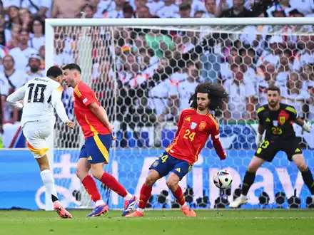 Spaniens Marc Cucurella (M) bekommt den Schuss von Deutschlands Jamal Musiala an den Arm. - Foto: Tom Weller/dpa