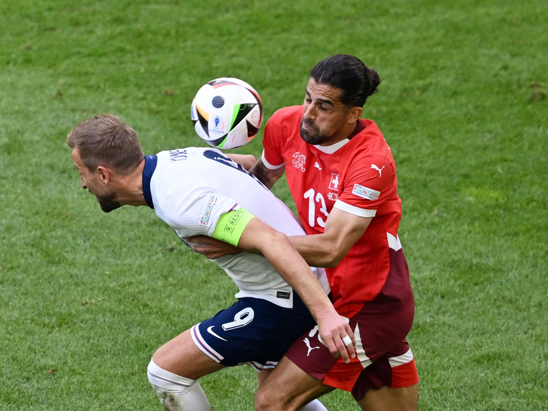Englands Harry Kane (l) und der Schweizer Ricardo Rodriguez kämpfen um den Ball. - Foto: David Inderlied/dpa