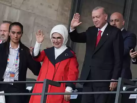 Recep Tayyip Erdogan (2.v.r), Präsident der Türkei, und seine Frau Emine Erdogan winken vor dem Spiel auf der Tribüne. - Foto: Marcus Brandt/dpa