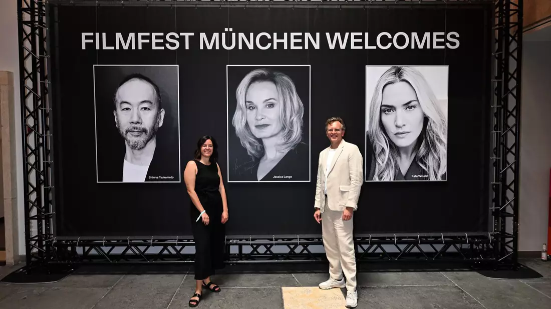 Schauspieler Robert Stadlober steht mit seinem Publikumspreis für den Film «Führer und Verführer» neben der Regisseurin Yasemin Samdereli, die für den Film «Samia» bei der Preisverleihung im Rahmen des Filmfest München ausgezeichnet wurde. - Bild: Felix Hörhager/dpa