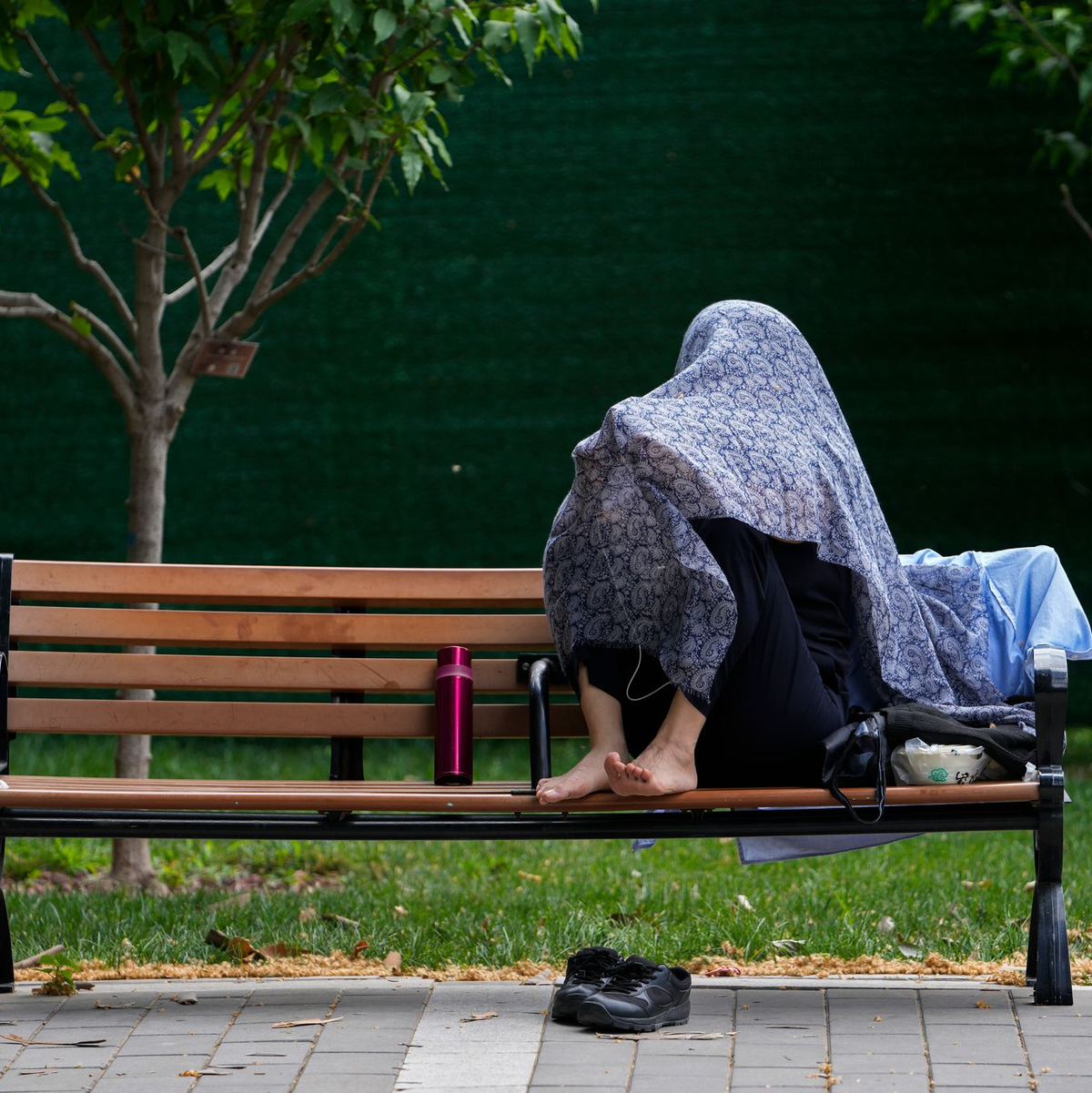 Eine Frau in China schützt sich mit einem Tuch vor der Sonne. - Foto: Andy Wong/AP