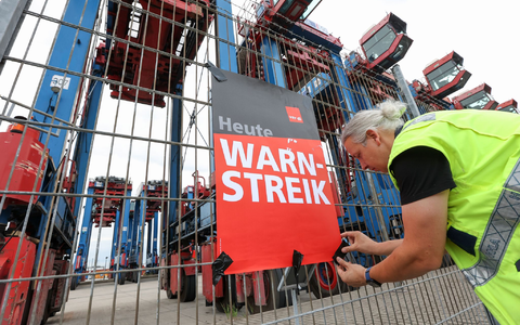 Ein Streikender hängt ein Plakat am Hamburger Hafen auf. (Archivfoto) - Foto: Bodo Marks/dpa