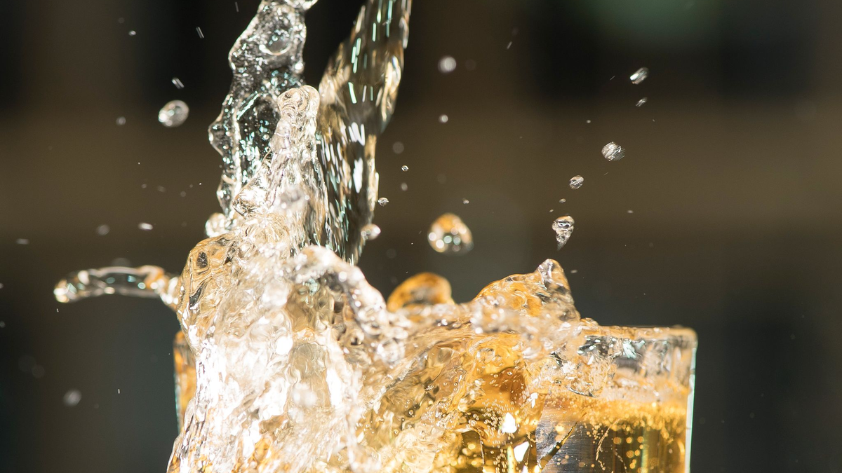 ILLUSTRATION: Apfelschorle spritzt aus einem Glas.  - Foto: Robert Günther/dpa-tmn/dpa