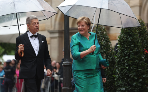 Im letzten Jahr mussten sich Angela Merkel und Ehemann Joachim Sauer auf den Weg ins Bayreuther Festspielhaus mit Regenschirmen schützen. (Archivfoto)  - Foto: Karl-Josef Hildenbrand/dpa