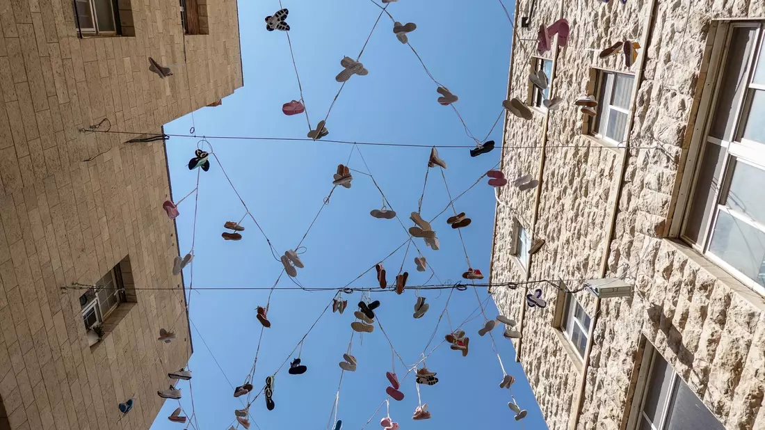 120 Paar Schuhe, als Installation in der Jerusalemer Innenstadt aufgehängt, erinnern an das Los der israelischen Geiseln in der Gewalt der Hamas.  - Bild: Nir Alon/ZUMA Press Wire/dpa