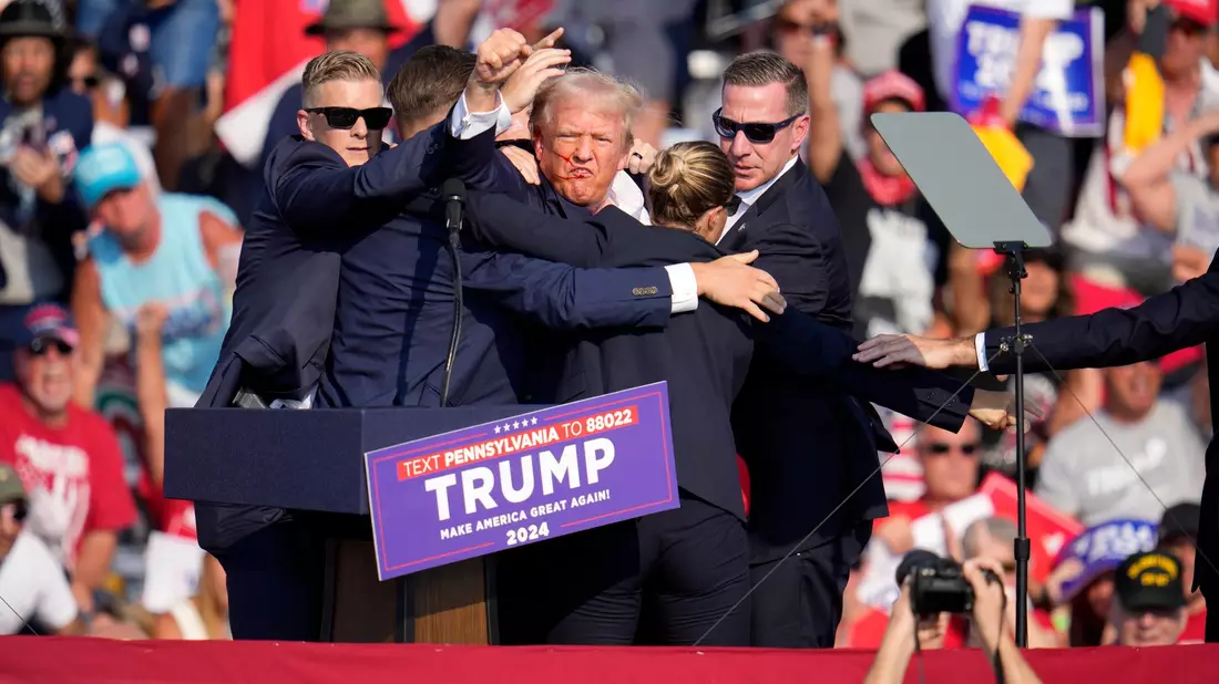 Trump wird verletzt von der Bühne geleitet. - Bild: Gene J. Puskar/AP/dpa