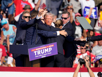 Trump wird verletzt von der Bühne geleitet. - Foto: Gene J. Puskar/AP/dpa