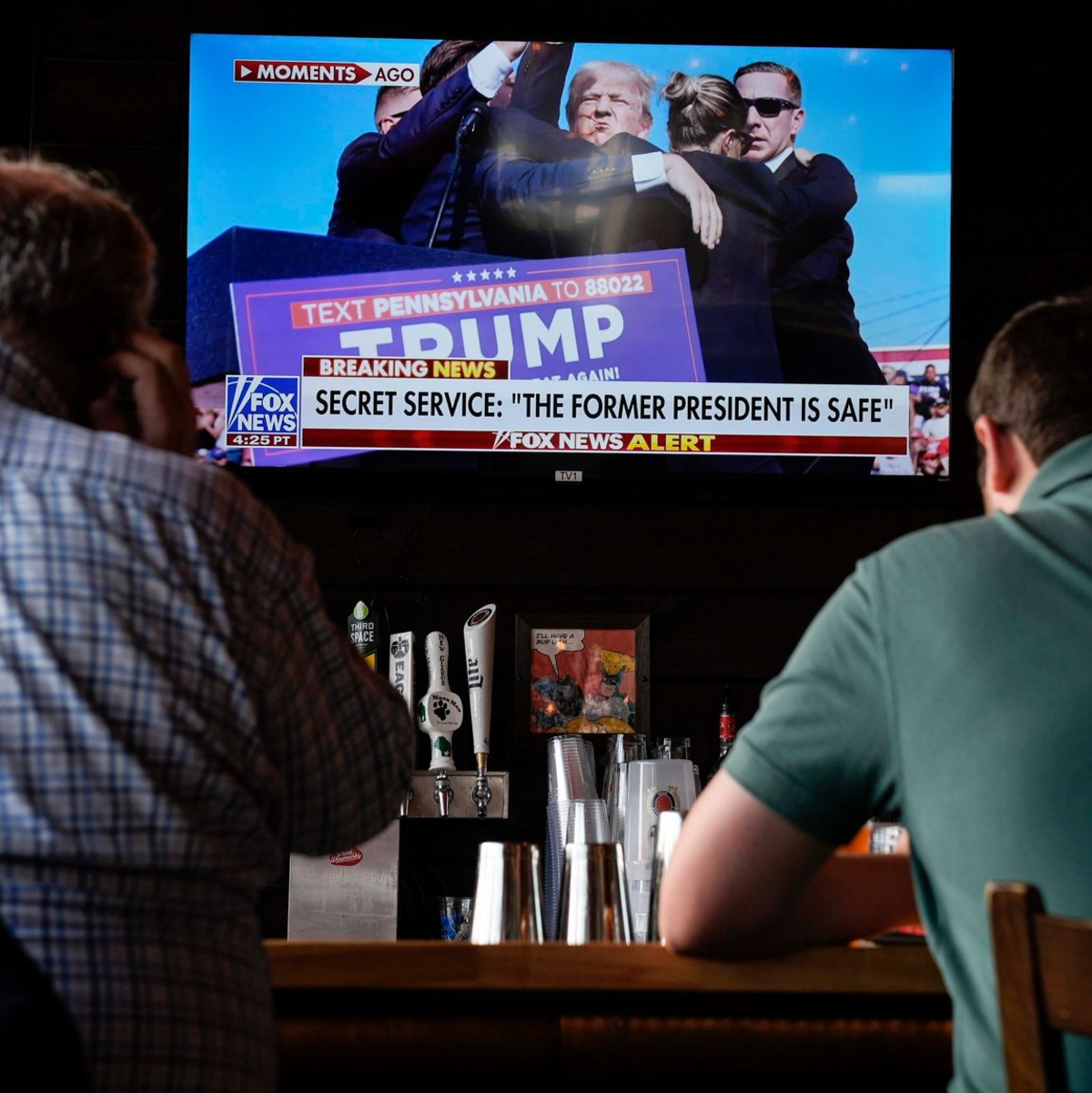 In Milwaukee im US-Bundesstaat Wisconsin verfolgen Männer in einer Bar die Berichterstattung über das Attentat auf Donald Trump. Ganz in der Nähe beginnt am Montag der Nominierungsparteitag der Republikaner. - Foto: Matt Rourke/AP/dpa
