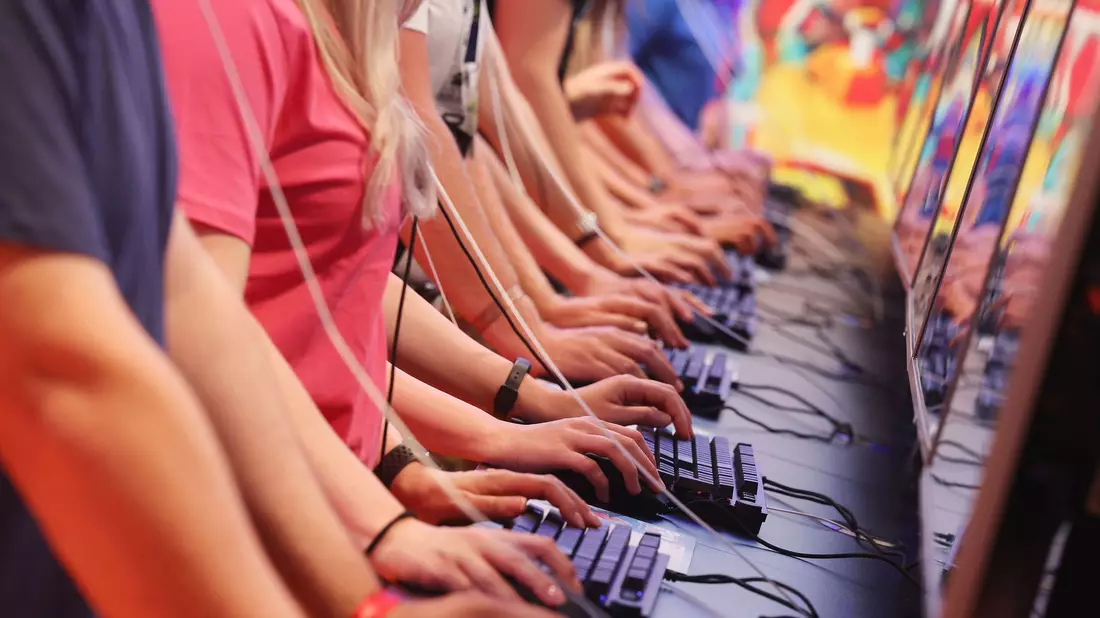 Messebesucher testen ein Computerspiel auf der Kölner Computer- und Videospielmesse Gamescom. Die deutsche Entwicklerszene setzt nach Auskunft eines Verbands in ihren Games immer stärker auf Themen der Demokratiestärkung. - Bild: Oliver Berg/dpa