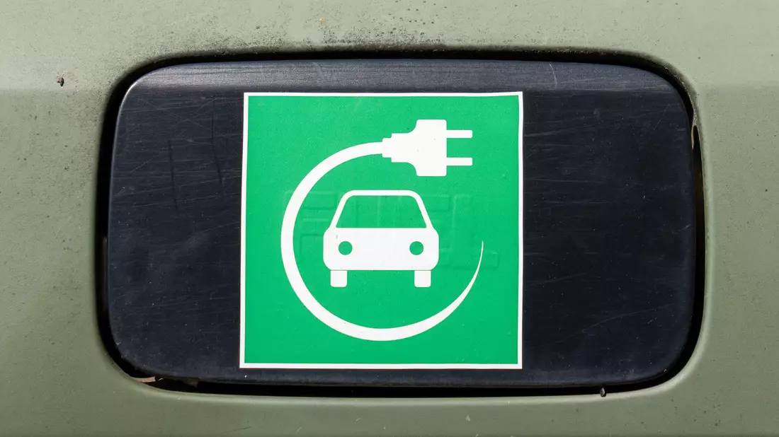 Ein Elektroauto-Symbol auf einem Auto.  - Bild: Soeren Stache/dpa