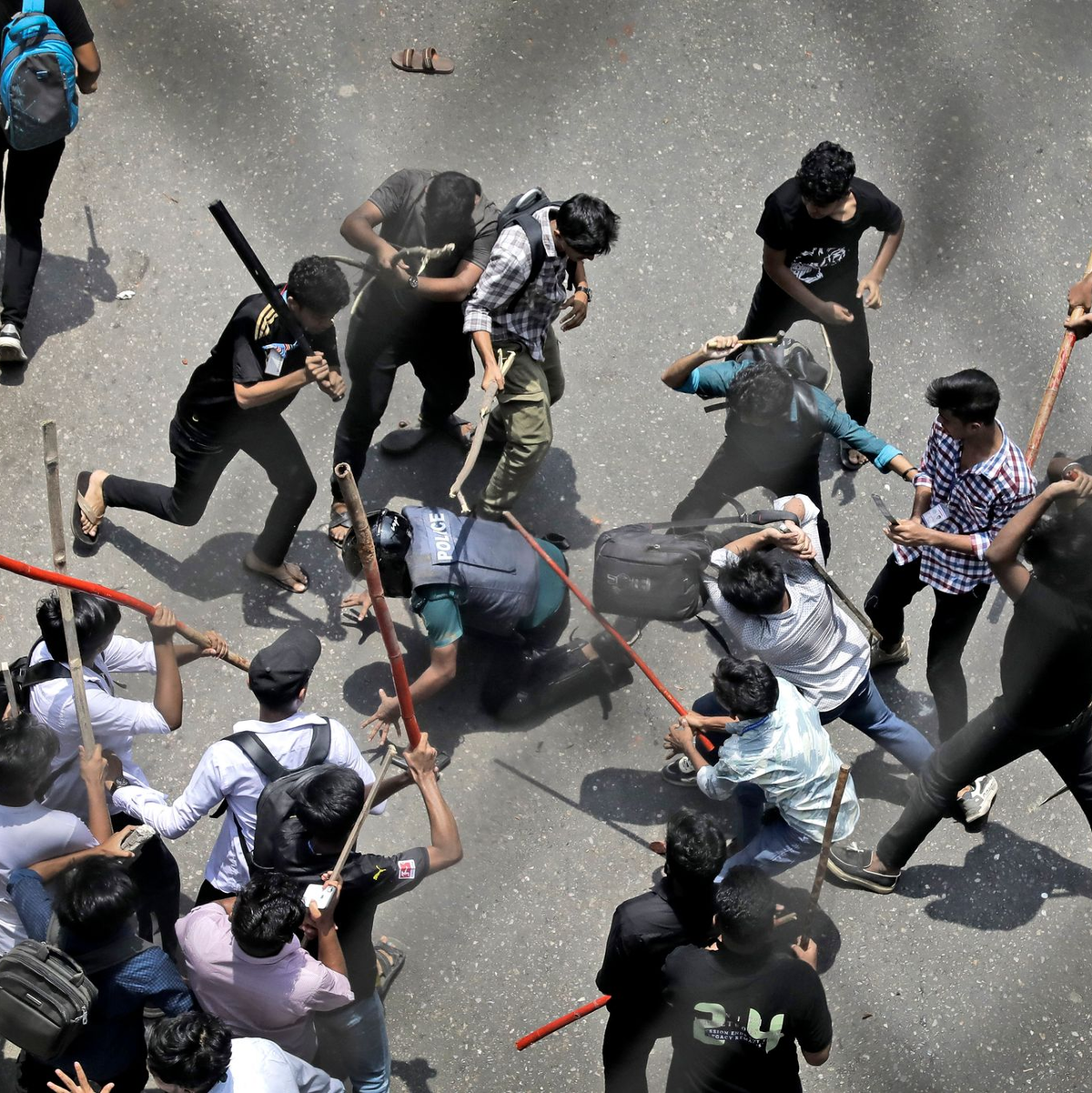 Studenten schlagen einen Polizisten mit Stöcken - Foto: Anik Rahman/AP/dpa