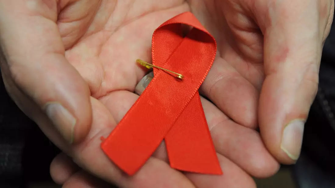 Dir rote Schleife ist ein Symbol der Solidarität mit HIV-Positiven und Aids-Kranken.(Archivbild) - Bild: Arne Dedert/dpa