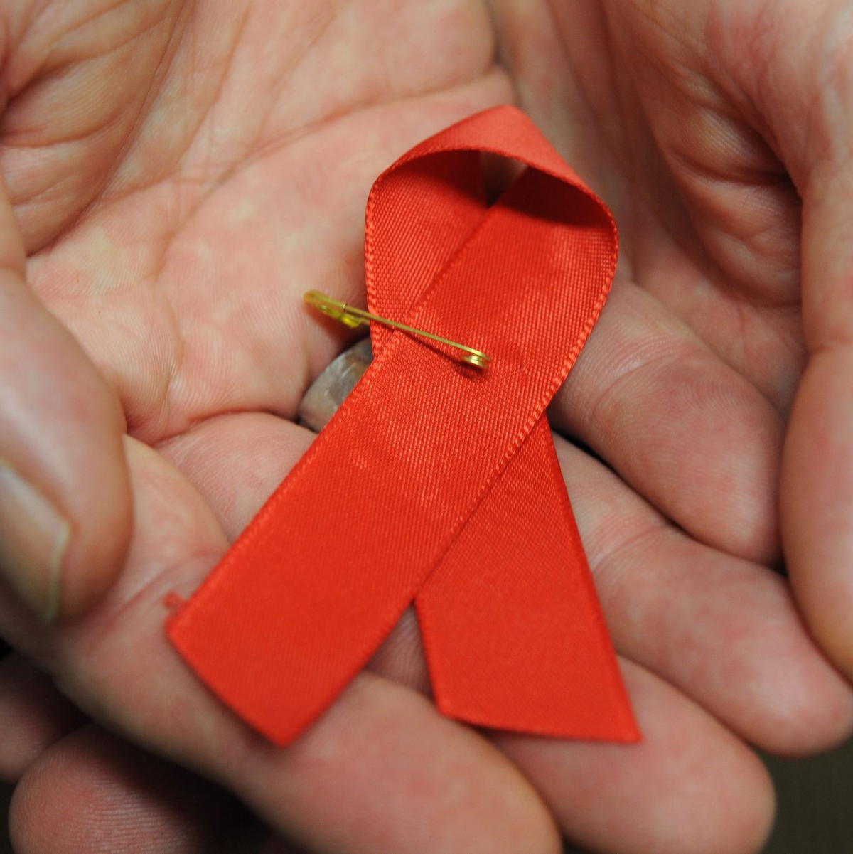 Dir rote Schleife ist ein Symbol der Solidarität mit HIV-Positiven und Aids-Kranken.(Archivbild) - Foto: Arne Dedert/dpa