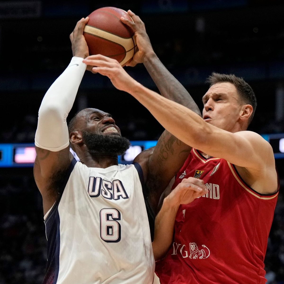 Superstar James auf dem Weg zum Korb gegen Deutschlands Co-Kapitän Voigtmann. - Foto: Alastair Grant/AP