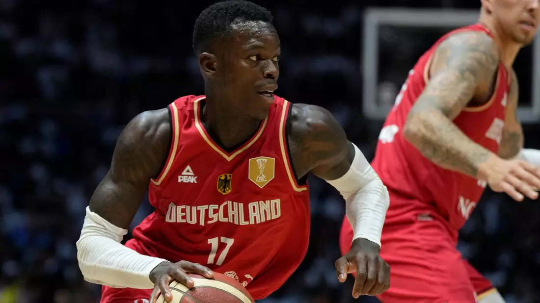 Dennis Schröder trägt bei der Olympia-Eröffnungsfeier in Paris die deutsche Fahne. - Bild: Alastair Grant/AP