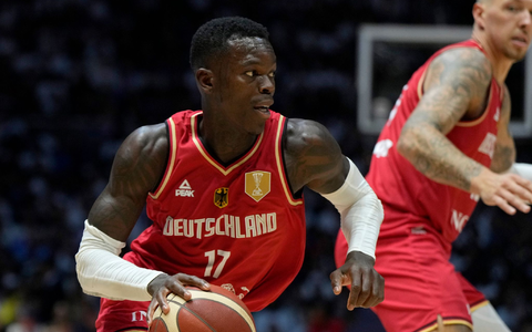 Dennis Schröder trägt bei der Olympia-Eröffnungsfeier in Paris die deutsche Fahne. - Foto: Alastair Grant/AP