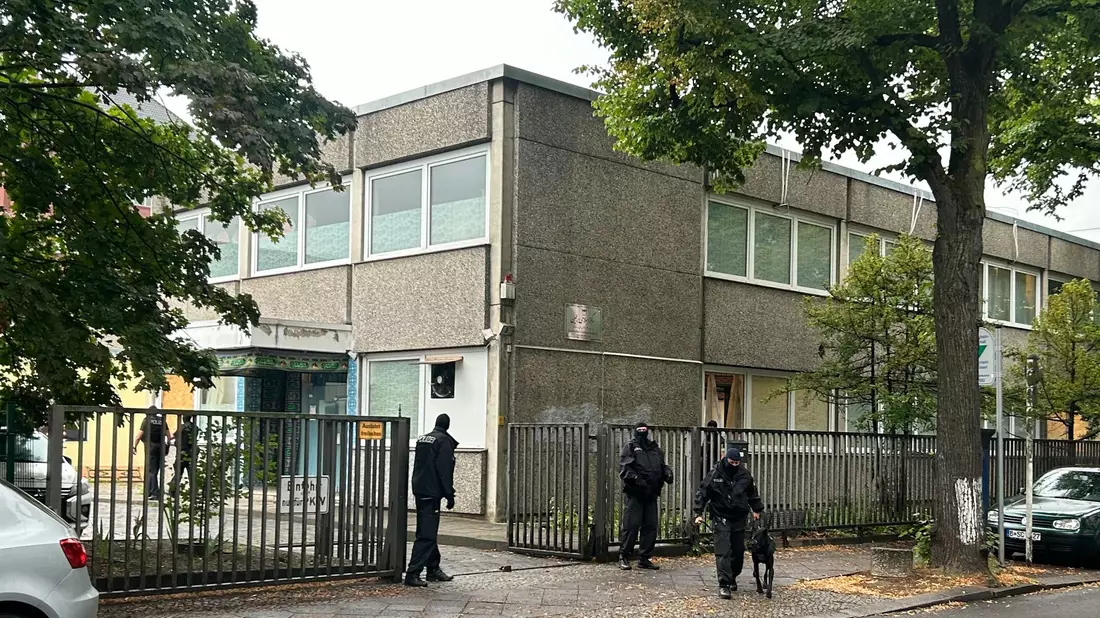 Vermummte Polizisten stehen an einem Gebäude, in dem sich das Islamische Zentrum Berlin befindet. - Bild: Sven Käuler/TNN/dpa