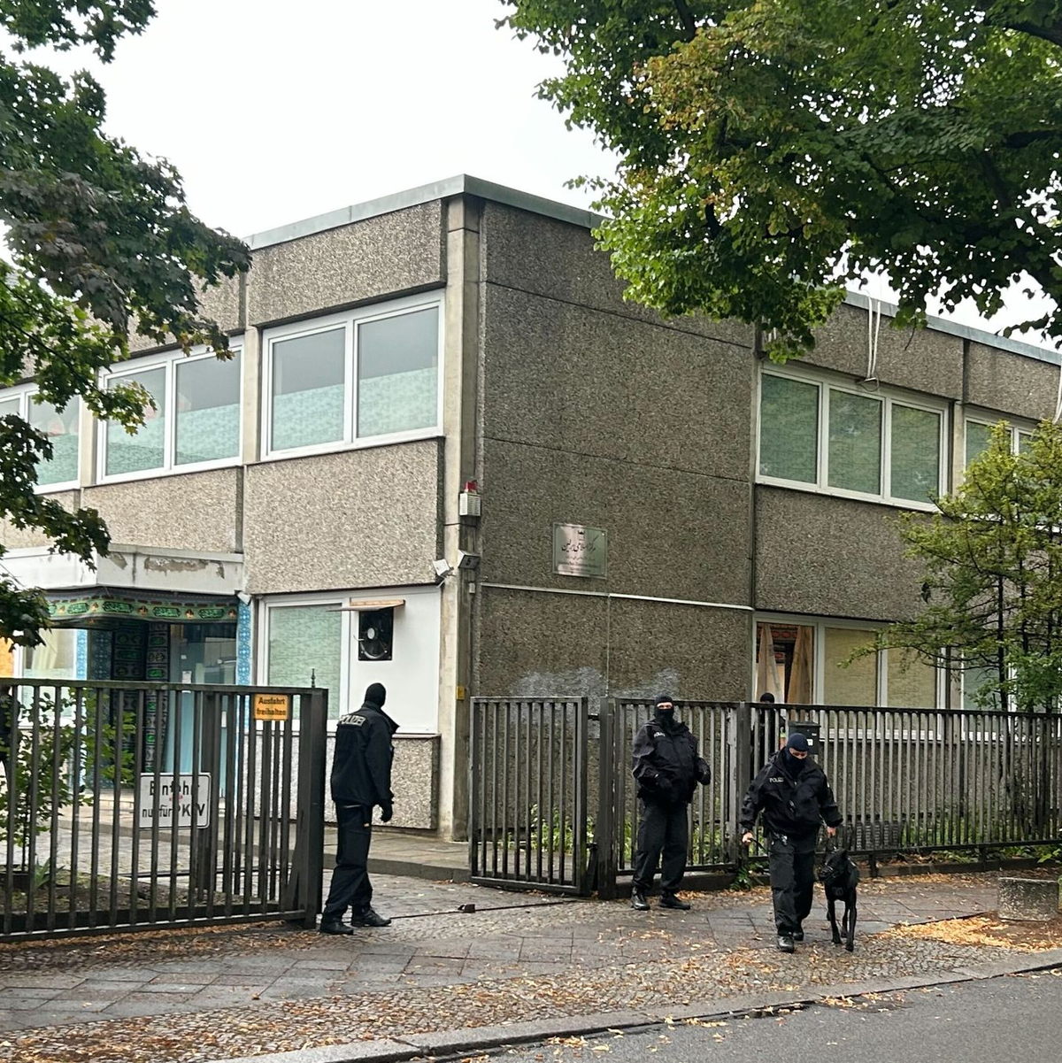 Vermummte Polizisten stehen an einem Gebäude, in dem sich das Islamische Zentrum Berlin befindet. - Foto: Sven Käuler/TNN/dpa
