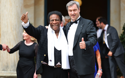 Markus Söder, Ministerpräsident von Bayern, und seine Frau Karin Baumüller-Söder, stehen zusammen mit Reiner Haseloff (CDU), Ministerpräsident von Sachsen-Anhalt, und seiner Frau Gabriele vor dem Bayreuther Festspielhaus. - Foto: Daniel Karmann/dpa