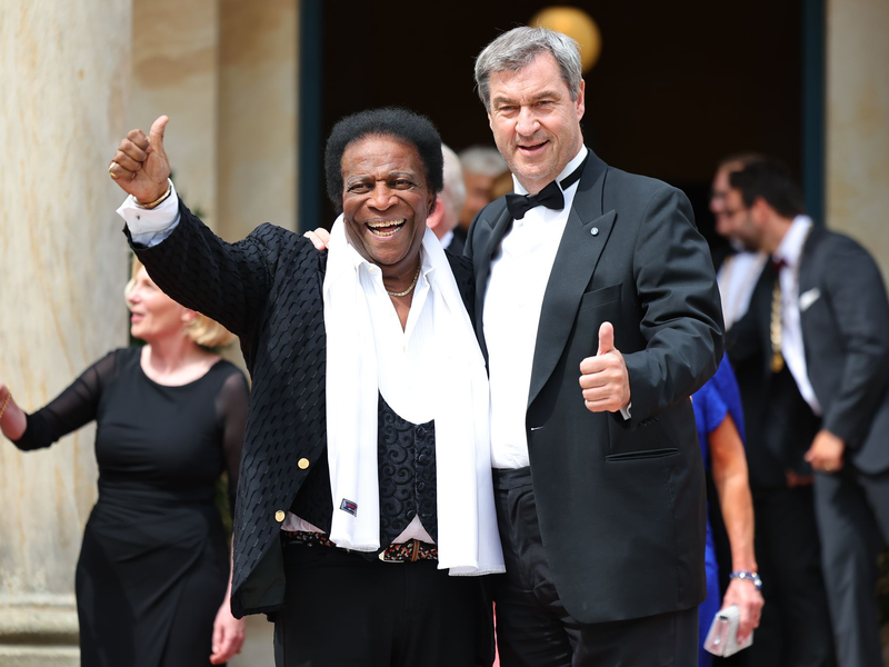 Markus Söder, Ministerpräsident von Bayern, und seine Frau Karin Baumüller-Söder, stehen zusammen mit Reiner Haseloff (CDU), Ministerpräsident von Sachsen-Anhalt, und seiner Frau Gabriele vor dem Bayreuther Festspielhaus. - Foto: Daniel Karmann/dpa