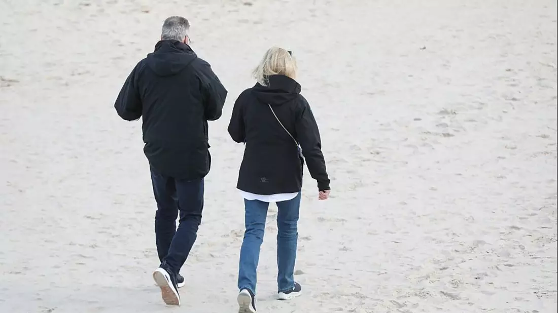 Paar geht am Strand spazieren - Bild: über dts Nachrichtenagentur