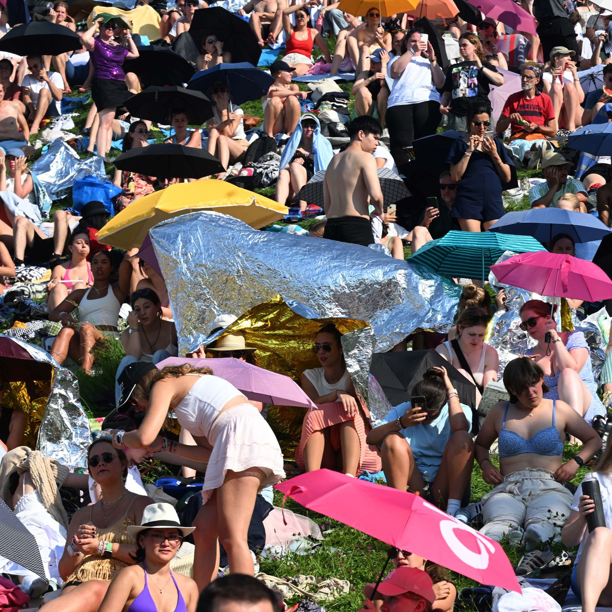 Mit Schirmen versuchten viele Fans, sich vor der Sonne zu schützen. - Foto: Felix Hörhager/dpa