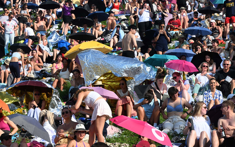 Mit Schirmen versuchten viele Fans, sich vor der Sonne zu schützen. - Foto: Felix Hörhager/dpa